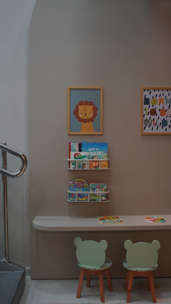 Espaço kids com mesinha, cadeiras infantis e quadros